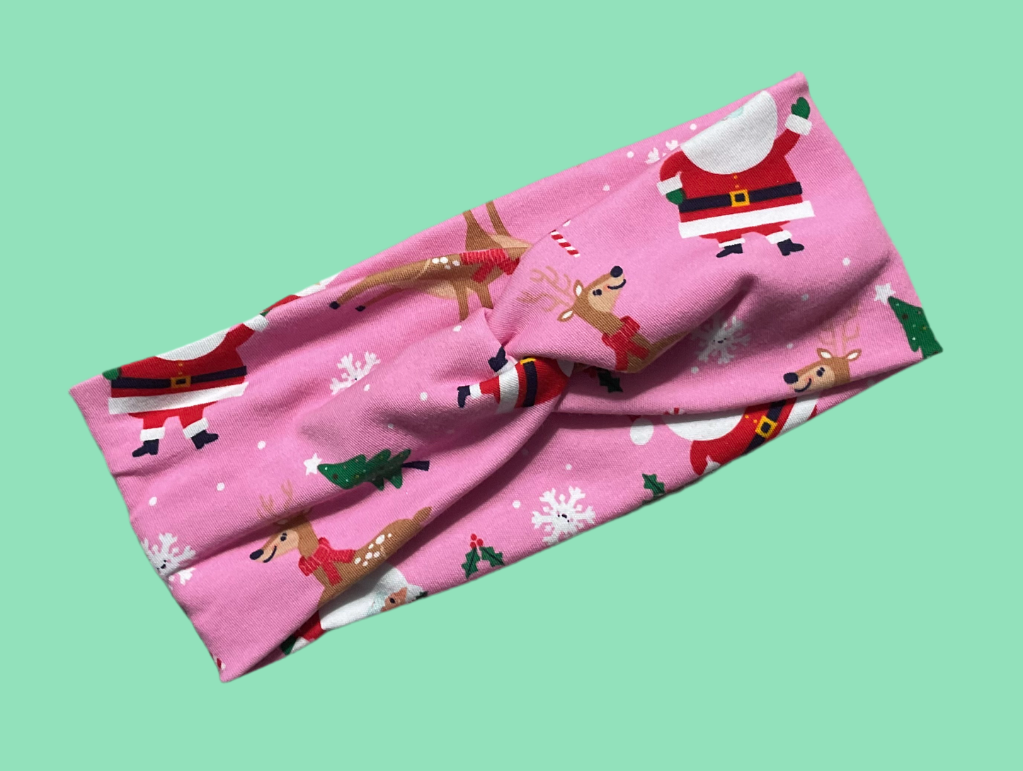 Wide twisted pink with Santa Christmas theme headband perfect for celebrating for the holiday season wear for sports, yoga, workouts or for fun fashionable and comfortable