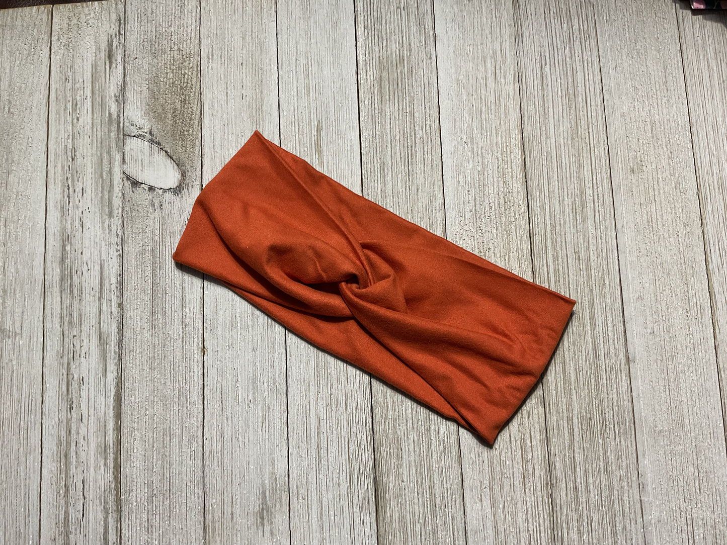 Wide twisted burnt orange headband for sports, yoga, workouts, facials, and more. Fashionable and comfortable