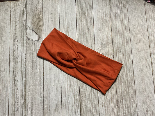 Wide twisted burnt orange headband for sports, yoga, workouts, facials, and more.  Fashionable and comfortable